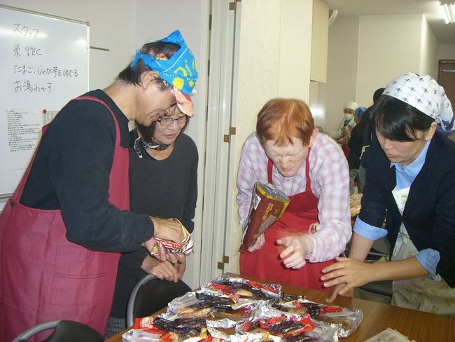 平田順士さん(右から2人目)と井上智文さん(左端)がお菓子を盛り付け